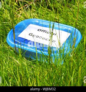 Concetto di geocaching con blue geocache box che mostra gli sport outdoor concept Foto Stock