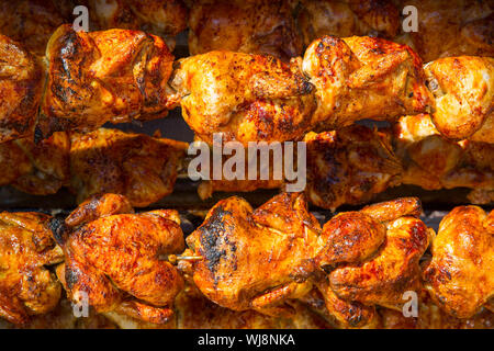 Pollo arrosto in una fila girando alla torrefazione industriale Foto Stock