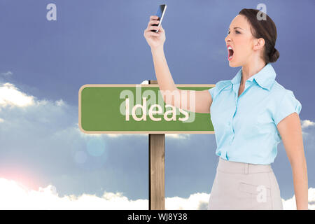 Immagine composita di angry classy imprenditrice a urlare contro il suo smartphone Foto Stock