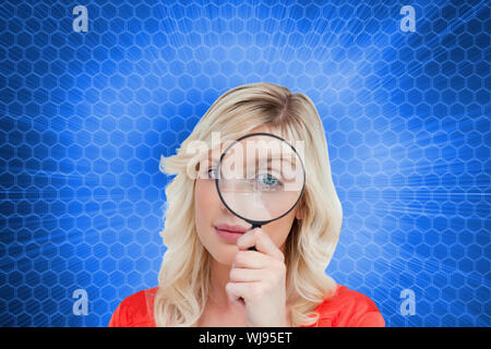 Immagine composita del biondo donna guardando attraverso una lente di ingrandimento Foto Stock