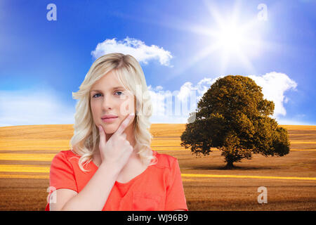 Immagine composita di adolescente in posizione eretta premurosamente con le dita sul suo mento Foto Stock