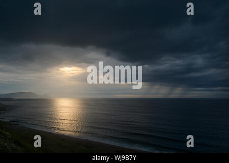 Seascape scuro con nuvole temporalesche e pioggia al tramonto Foto Stock