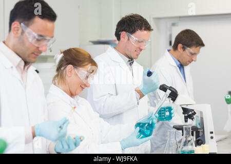 Vista laterale di un gruppo di scienziati impegnati in laboratorio Foto Stock