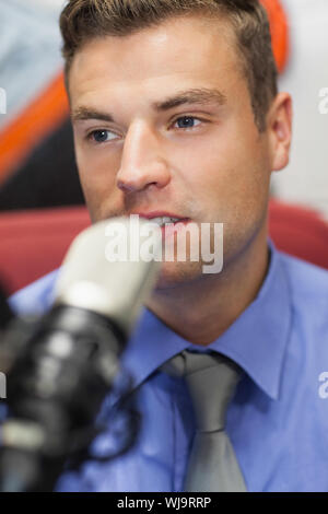 Ben vestito concentrando host radio moderare in studio presso il college Foto Stock