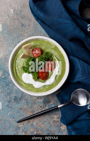 Close up minestra in crema di broccoli, cucchiaio e tovagliolo. Vista superiore, picture per la ricetta Foto Stock