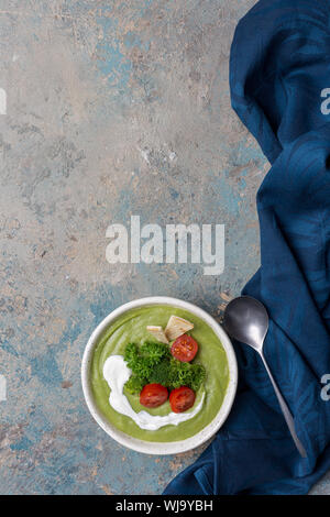 La raccolta di zuppa con broccoli, pomodori ciliegini, il prezzemolo e il cucchiaio e Tovagliolo Foto Stock