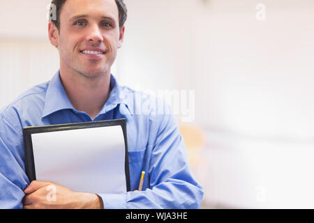 Close up ritratto di un elegante insegnante maschio con blocco note contro sfondo sfocato Foto Stock