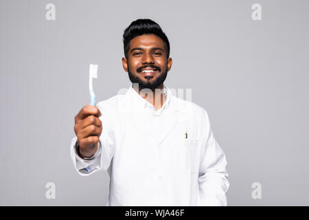 Closeup ritratto di dentista tenendo premuto fino dello spazzolino e del pollice in alto segno, isolato su sfondo bianco con spazio di copia Foto Stock