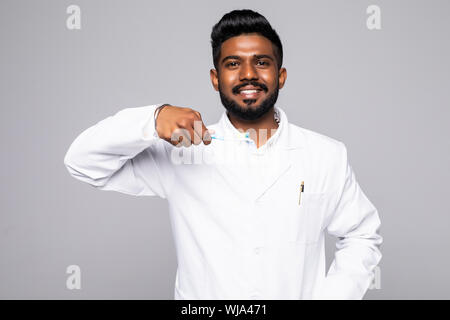 Closeup ritratto di dentista tenendo premuto fino dello spazzolino e del pollice in alto segno, isolato su sfondo bianco con spazio di copia Foto Stock