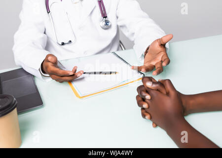 Close up uomo indiano medico hanno una consultazione con premuto africano paziente femmina in clinica Foto Stock