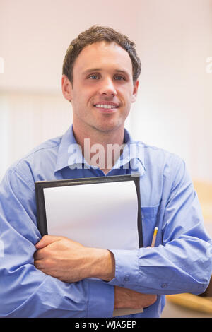 Close up ritratto di un elegante insegnante maschio con blocco note contro sfondo sfocato Foto Stock