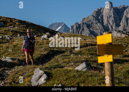 Una donna trekking vicino al rifugio Lacs Merlet nel Parc National de la Vanoise, la Vallee des Avals, Courchevel, Alpi francesi. Foto Stock