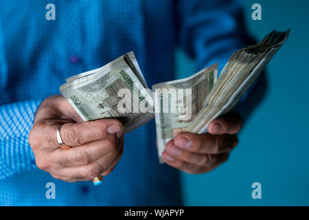 Indian business man contando appena lanciato indian cinquecento rupie. Il denaro conta il concetto di sfondo con copia spazio. Foto Stock