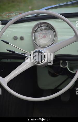 Dettaglio interni di un Fiat Nuova 500 auto classica che mostra il volante il tachimetro e il cruscotto Foto Stock