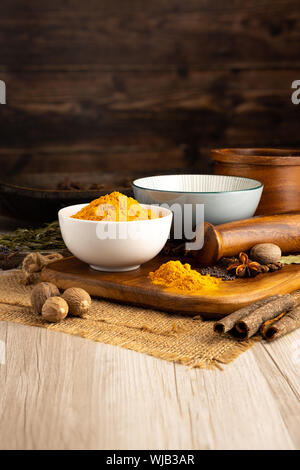 Asciugare la curcuma macinata in una ciotola e in un ambiente da cucina Foto Stock