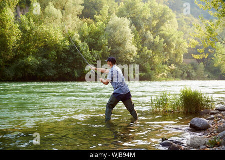 Metà uomo adulto su vacanze sul fiume, rilassante e la Trota di pesca Foto Stock