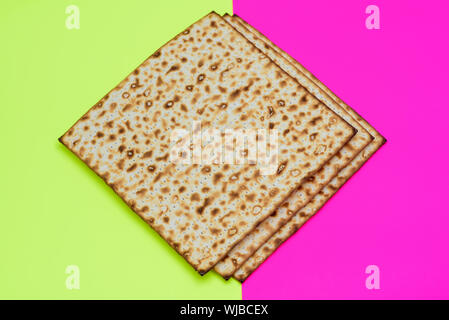 Matzah su rosa gialla sfondo alla moda.Matza -ebraico di pasqua tradizionale pane azzimo. Il Pesach celebrazione simbolo. Foto Stock