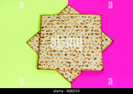 Matzah su rosa gialla sfondo alla moda.Matza -ebraico di pasqua tradizionale pane azzimo. Il Pesach celebrazione simbolo. Foto Stock