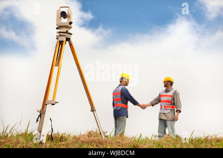 Due Surveyor handshaking ingegneri sul campo Foto Stock