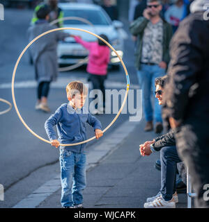 Bambini che giocano con rollbar di hula, Menningarnott o Culturale giorno, Reykjavik, Islanda. Strada chiusa alle auto. Foto Stock