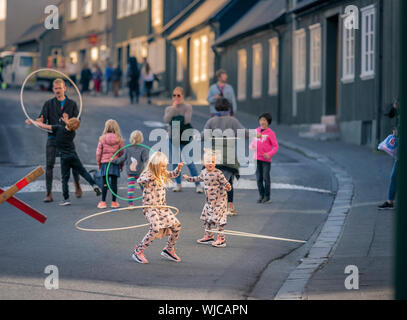 Bambini che giocano con rollbar di hula, Menningarnott o Culturale giorno, Reykjavik, Islanda. Strada chiusa alle auto. Foto Stock