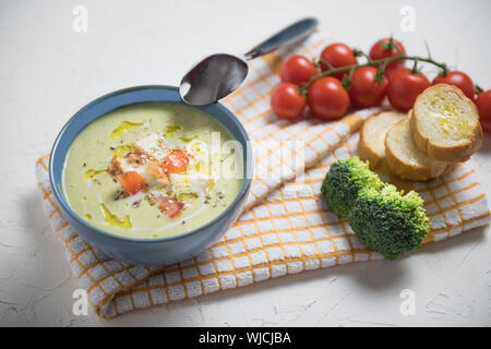 Ciotola di crema di broccoli zuppa, crostini con olio di oliva e gli ingredienti, cibo vegetariano Foto Stock