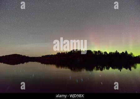 Una debole Aurora (Northern lights) display riflette in San Pothier Lago Maggiore Sudbury, Ontario, Canada Foto Stock