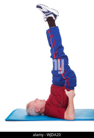 Ritratto di uomo anziano a praticare Yoga su sfondo bianco Foto Stock