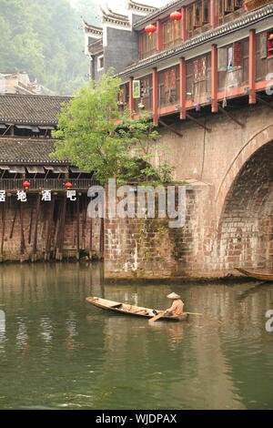 FENGHUANG - 12 Maggio: imbarcazione in legno e case in legno al fiume tuojiang in fenghuang antica città il 12 maggio 2011 di Fenghuang, Cina. Foto Stock