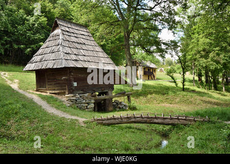 Mulino ad acqua tradizionale e ponte costituito da un tronco di albero. Prigor, Caras-Severin county. ASTRA Museo della Musica Folk tradizionale civiltà, un open-air muse Foto Stock