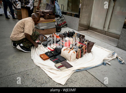 Un venditore imposta negozio di vendita donna knock-off borsette sulla Fifth Avenue a New York Sabato, Agosto 31, 2019. (© Richard B. Levine) Foto Stock