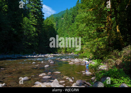 Little Boy giocando sulle rive del fiume di salmoni in Mt. Hood National Forest Foto Stock