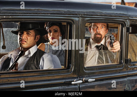 Gruppo di 1920s vintage gangster in auto dal tiro Foto Stock