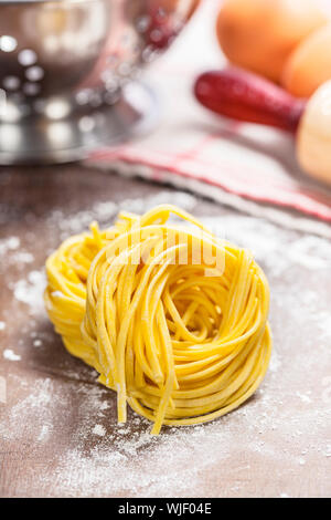 Rendendo la pasta fatta in casa sul tavolo di legno Foto Stock