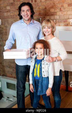 Giovane uomo con la sua azienda familiare scatole per pizza Foto Stock