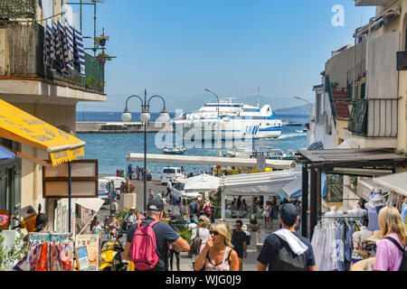 Isola di Capri - Agosto 2019: People shopping nella porta sull'Isola di Capri. In background, un traghetto veloce è in arrivo in porto. Foto Stock