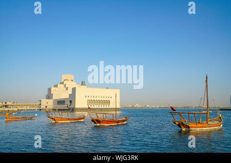 Quattro dhow ormeggiati nella baia con il Museo di Arte Islamica edificio in background. Foto Stock