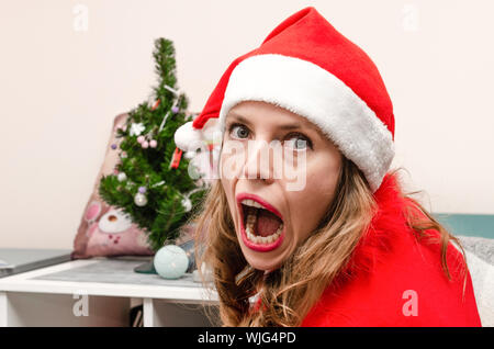 Ritratto di un sconvolto donna bionda vestita in rosso Anno Nuovo costume Foto Stock