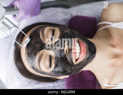 Carino donna coreana ottiene un peeling viso procedura in un salone di bellezza. Cura della Pelle Foto Stock