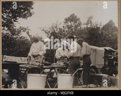 Henry Ford e Harvey Firestone assistere i due chef mediante pelatura patate a Ford-Edison viaggio di campeggio Foto Stock