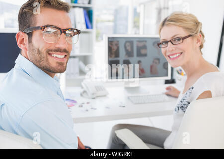 Vista posteriore del ritratto di fotografia lavorando sul computer in un ufficio luminoso Foto Stock