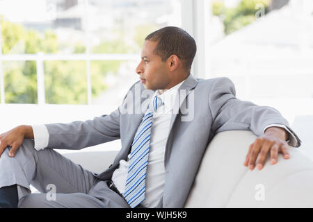 Imprenditore serio pensando sul lettino in ufficio Foto Stock