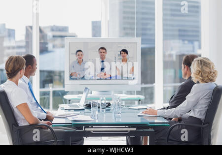 Team aziende aventi video conferenza con un altro team business di office Foto Stock