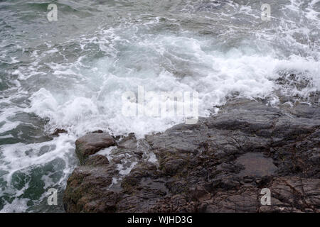 Il mare di lavaggio sulle rocce al Porto di Saltcoats Foto Stock