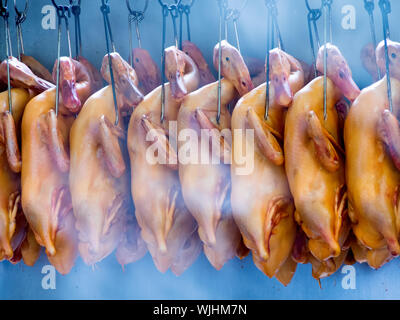 Chiudere fino a crudo intero anatre appeso su ganci Foto Stock