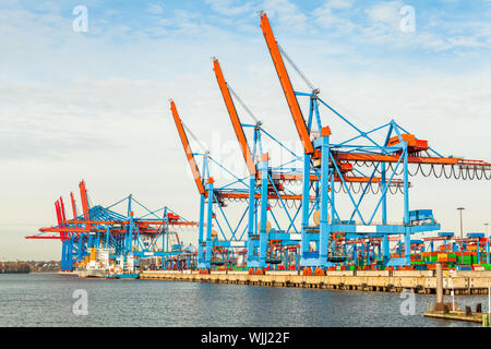 Abbandonato il terminale di porta di un porto per il carico e scarico delle navi da carico e il trasporto di merci con righe di grandi gru industriali per sollevare merci off ponte Foto Stock