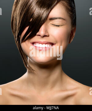 Ridere ragazza adolescente con gli occhi chiusi. Frangia elegante Foto Stock