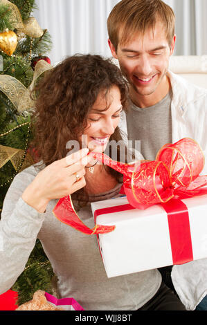 Regalo di natale. Coppia felice con Natale e Anno Nuovo dono a casa Foto Stock