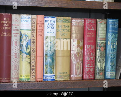 Una fila di libri con il distintivo illustrato spine da publisher Walter Blackie, sul display nella libreria della Collina Casa costruita per lui dal CRM. Foto Stock