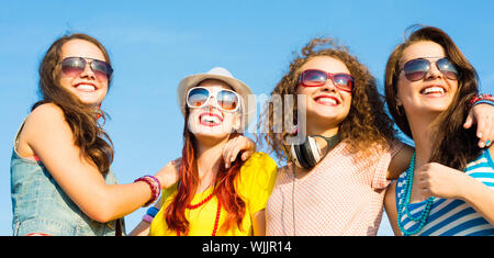 Un gruppo di giovani che indossa gli occhiali da sole e cappello Foto Stock